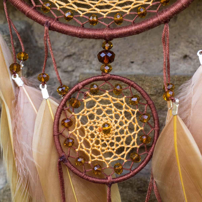 Dream catcher with amber beads and feathers, a craft idea made with waxed cord