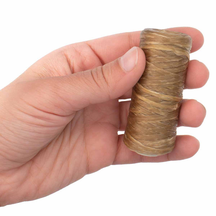 Hand holding a small spool of waxed polyester artificial sinew to show its size