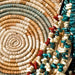 Woven coiled basket with turquoise, red and white bead strands, a traditional craft use for sinew