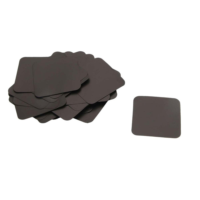 BeadSmith anti-tarnish tabs, a pile of dark gray 1 inch squares with rounded corners and one tab set apart