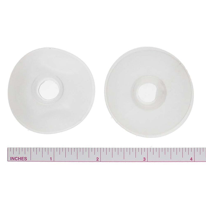 Two bobbins seen from the top with their center holes, placed above an inch ruler to show diameter