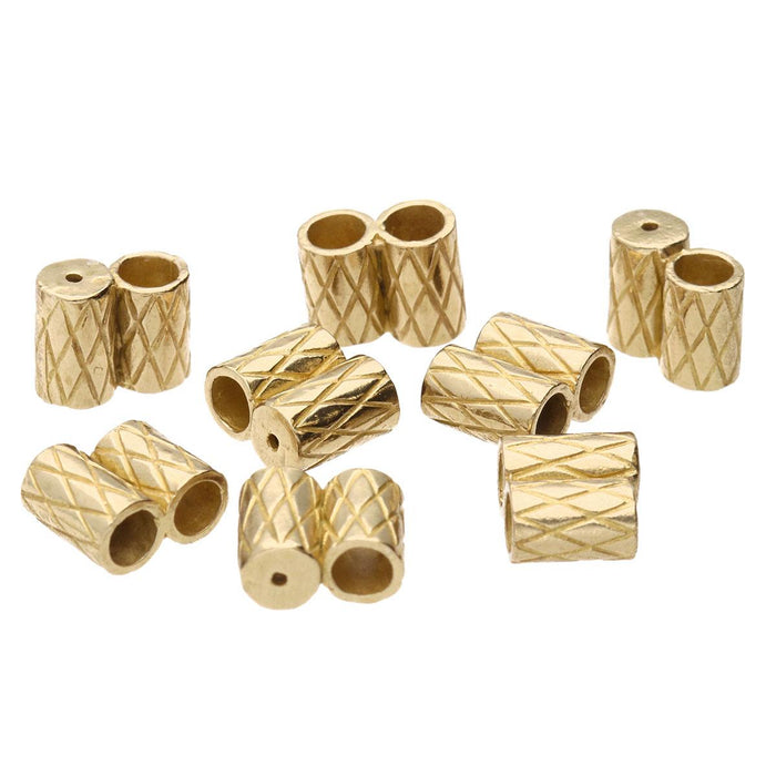 Group of brass slide clasps scattered together, showing the crosshatch texture and open tube ends