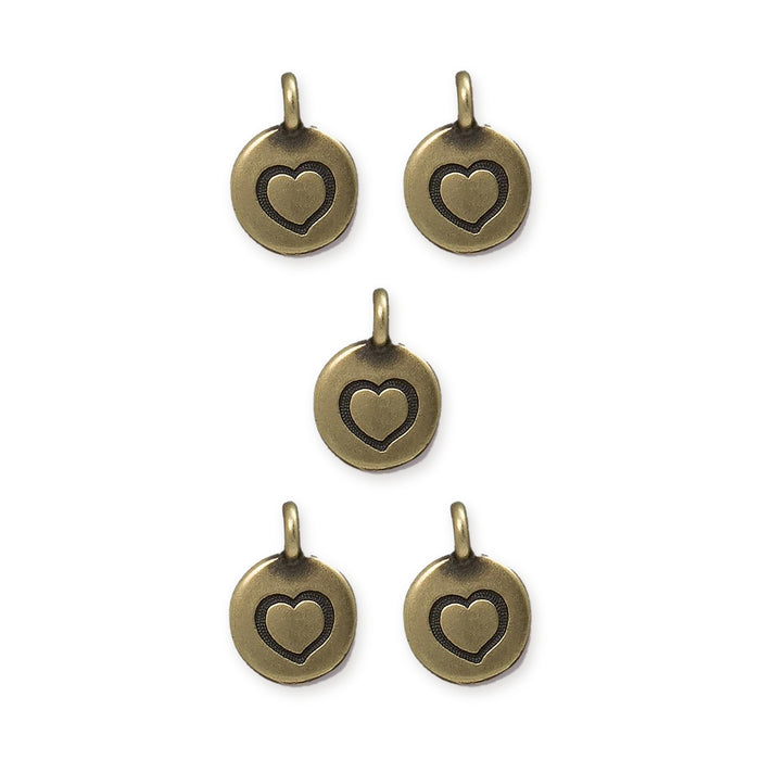Antiqued brass heart charms, five round pewter charms with stamped hearts and top loops arranged in a group