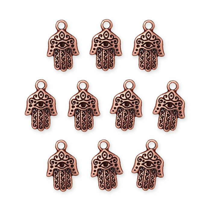 Antiqued copper hamsa hand charms with eye and scroll detail, ten charms arranged in rows on white