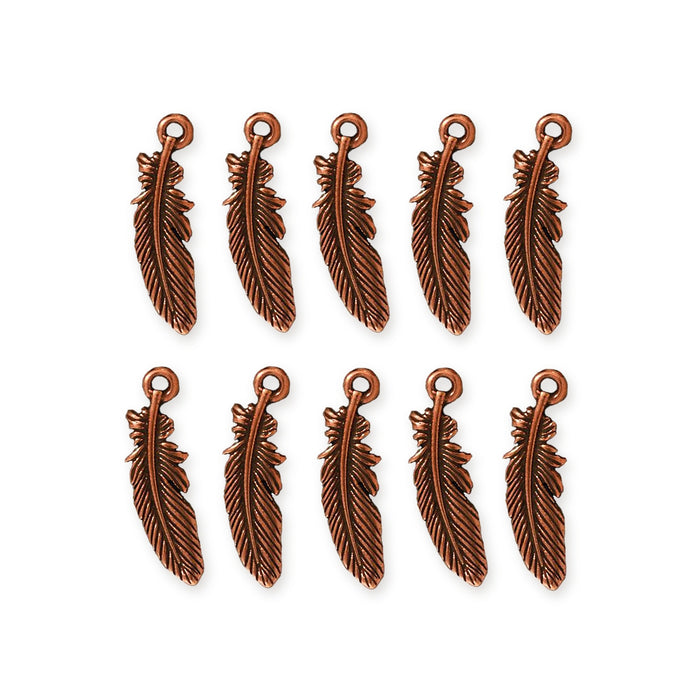 Antiqued copper feather charms, ten pieces arranged in two rows on a white background