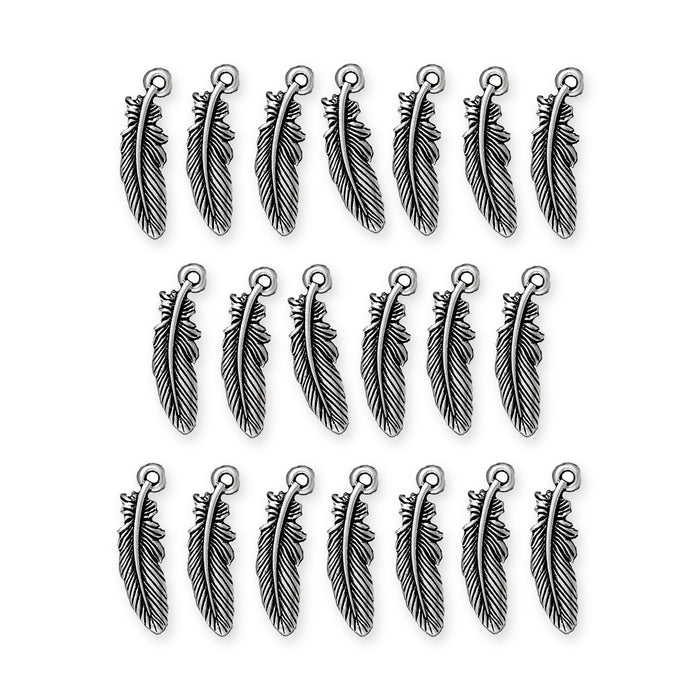Antiqued silver feather charms laid out in three rows on a white background