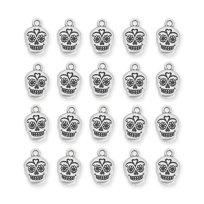 Antiqued silver sugar skull charms arranged in a grid of four rows on a white background