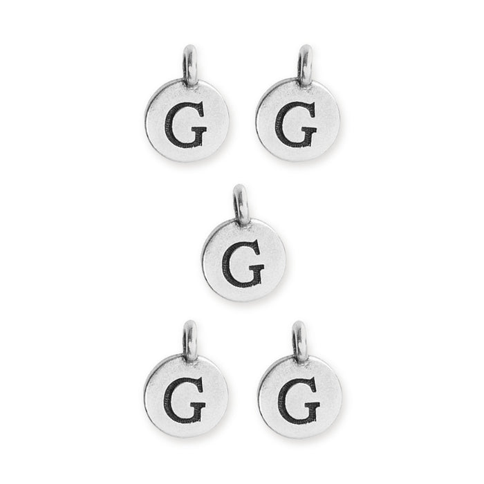 Antiqued silver letter G charms, five round pewter charms with loops arranged on white