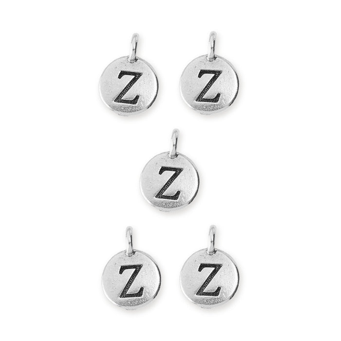 Antiqued silver letter Z charms, five round pewter charms with loops arranged on a white background