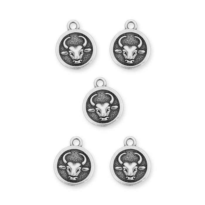 Antiqued silver Taurus zodiac charms, five round pewter charms each showing a bull's head, laid out on white