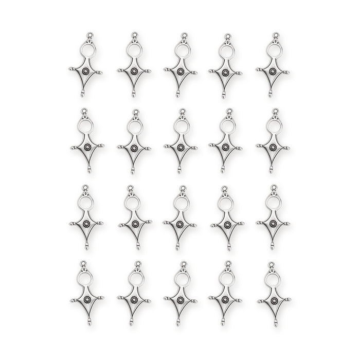 Antiqued silver Tuareg cross motif pendants arranged in four rows of five on a white background
