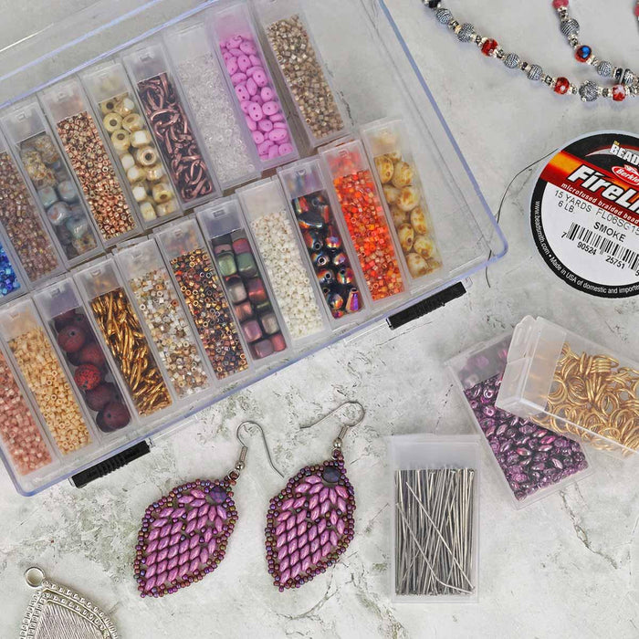 Organizer case filled with colorful seed beads, shown from above with earrings, beading cord and findings