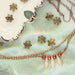 Antiqued brass flower bead caps near a copper chain necklace with copper pearls and cream dagger beads