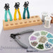 BeadSmith One Step Looper on a work mat beside a wooden plier stand, wire spools and a tray of beads