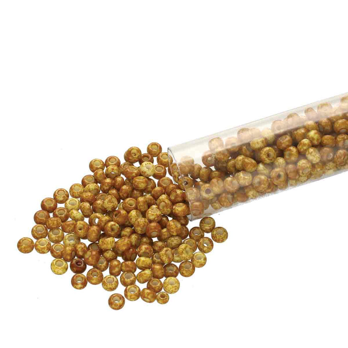 Brown travertine Czech glass seed beads spilling from a clear tube, showing the mottled golden finish