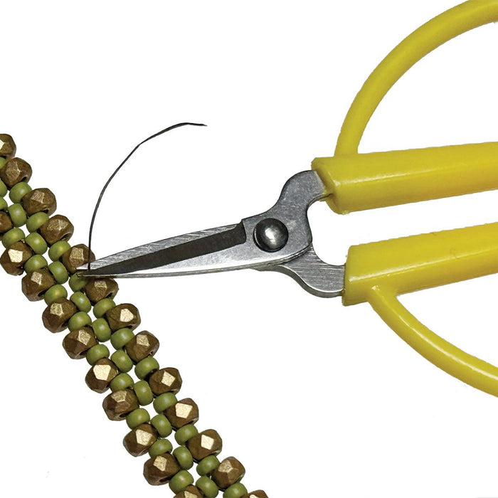 Close-up of the mini scissors blades snipping thread beside a beaded green and bronze strand
