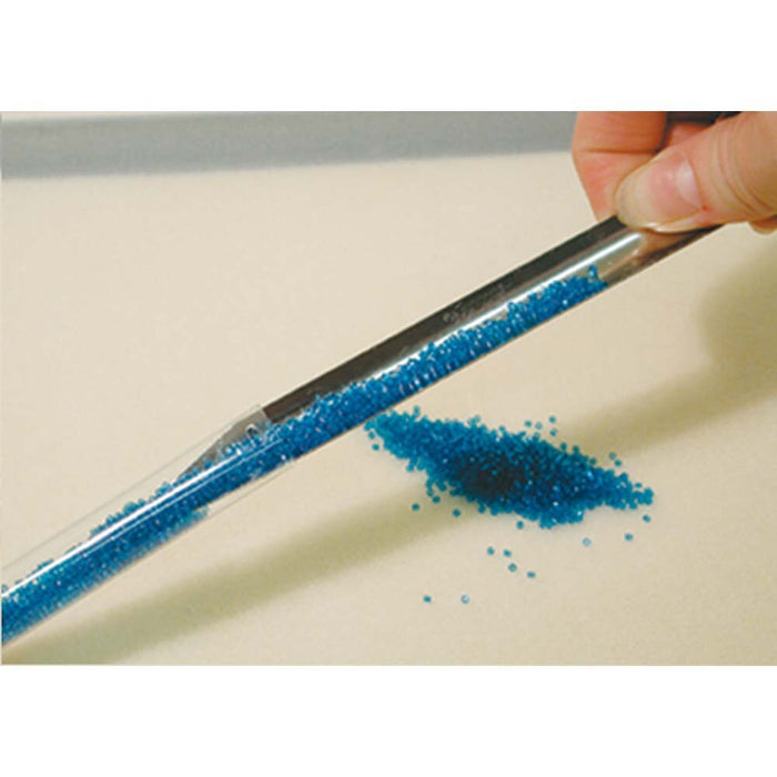 Scoop-EEZ bead scoop pouring tiny blue seed beads into a clear tube, with loose beads on the surface below