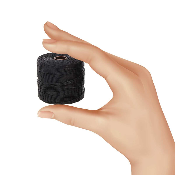 Hand holding a spool of black S-Lon nylon bead cord to show its size