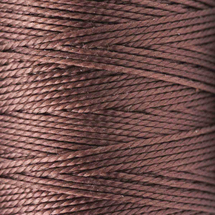 Close-up of the twisted 3-ply texture of brown S-Lon nylon bead cord wound on a spool