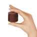 Small brown S-Lon nylon bead cord spool held between a thumb and fingers to show its size
