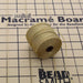 Bronze S-Lon bead cord spool with loose cord strands lying on a mini macramé board with grid