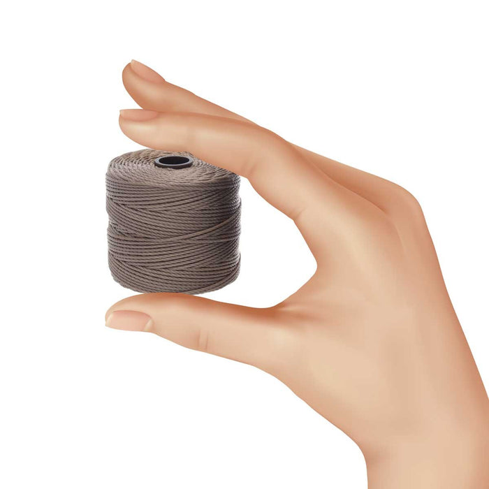 Hand holding a small spool of cocoa nylon bead cord to show its size