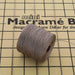 Cocoa nylon bead cord spool resting on a mini macramé board with cord strung across the grid