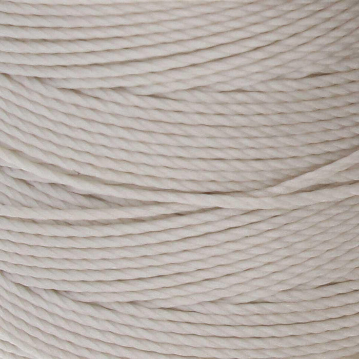 Close-up of the twisted texture of cream S-Lon nylon bead cord wound tightly on the spool