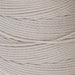 Close-up of the twisted texture of cream S-Lon nylon bead cord wound tightly on the spool