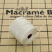Spool of S-Lon cream nylon bead cord resting on a mini macrame board with cord strands pinned across it
