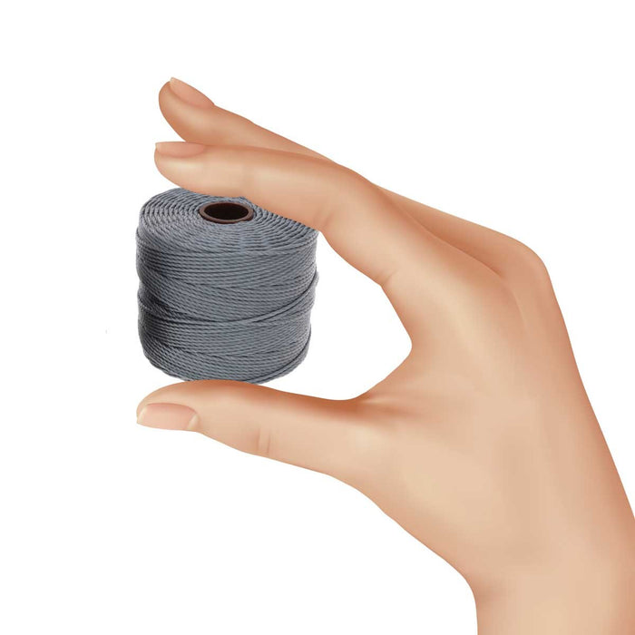 Hand holding a small spool of grey S-Lon nylon bead cord to show its size