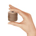 Hand holding a small spool of light brown S-Lon nylon bead cord for size reference