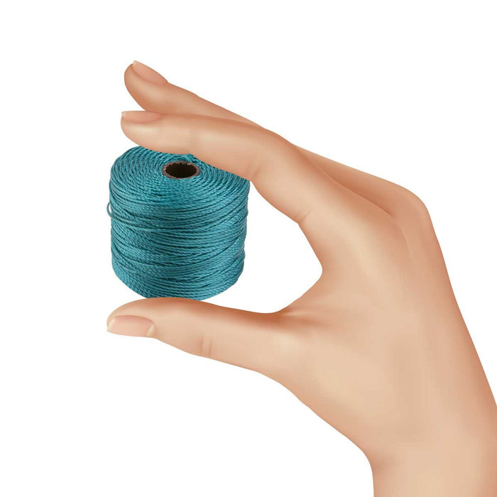 Hand holding a small spool of teal S-Lon nylon bead cord to show its size