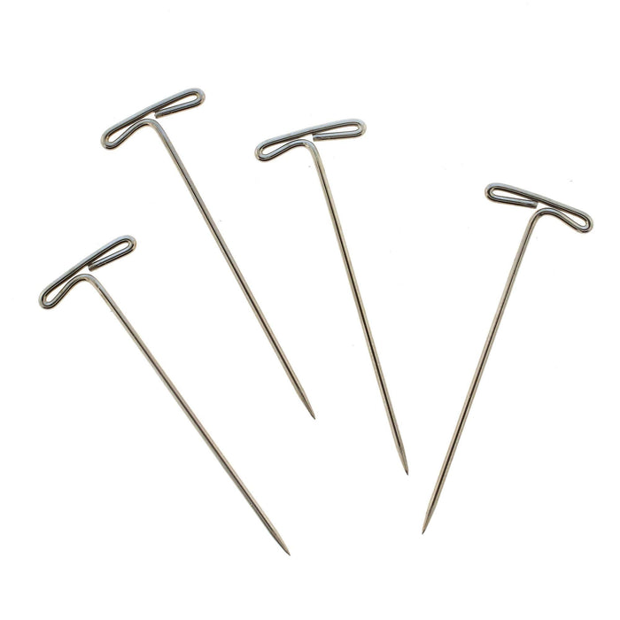 Close-up of four steel T-pins showing the looped T-shaped heads and pointed tips