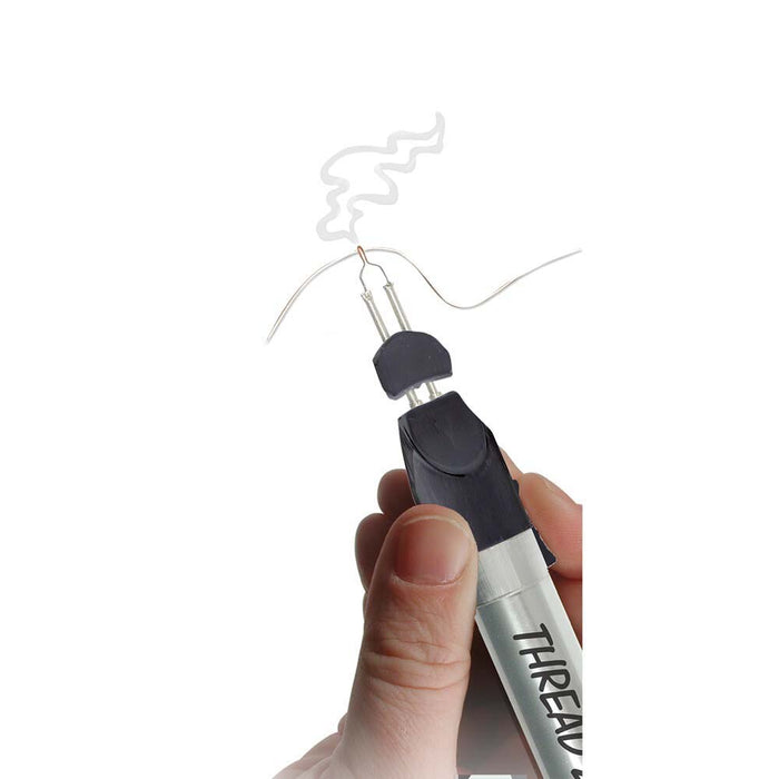 Hand holding the Thread Zap II thread burner as the heated tip singes a thin thread