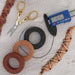 Waxed linen cord spools in tan, brown and black with scissors, digital caliper and finished macrame bracelets