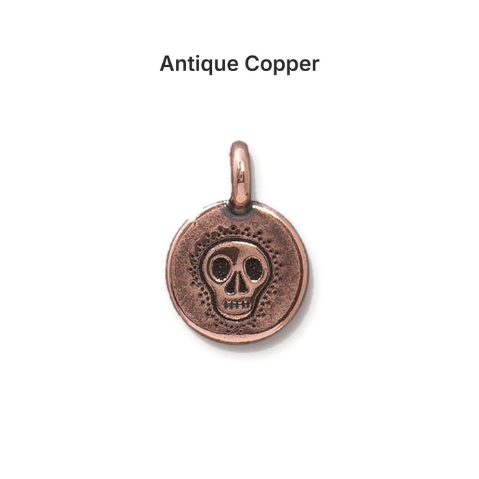 Antiqued copper skull coin charm, front