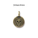 Antiqued brass skull coin charm, front