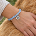 Antiqued silver paw print coin charm on a light blue bead bracelet, design idea