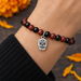 Antiqued silver sugar skull charm on an onyx and jasper bead bracelet, design idea